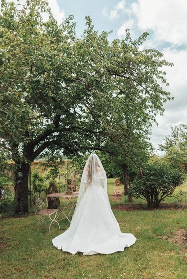Mariée de dos dans un jardin, quelques instants avant la découverte.