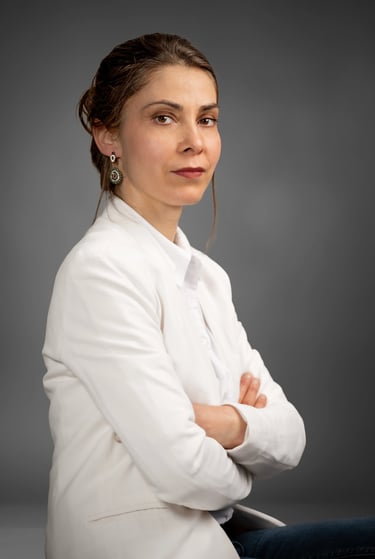 a corporate woman in a white shirt and jeans sitting on a chair