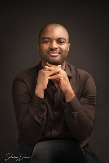 a corporate man in a brown shirt and black pants crossing his hands