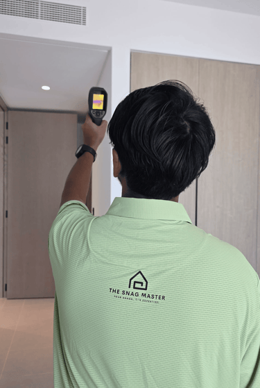 Engineer using thermal imaging camera to detect hidden moisture during property snagging inspection