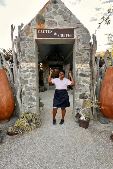a waitress inviting tour groups and tourists to a coffee shop in uis namibia
