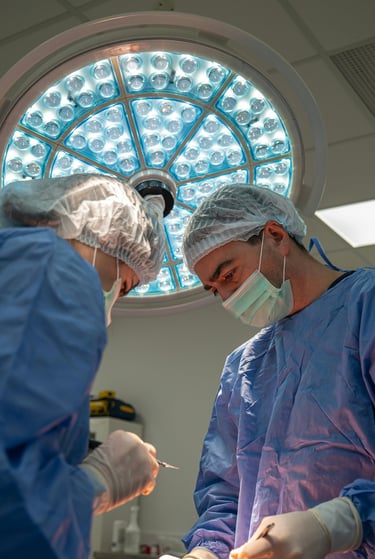 Surgeons performing a surgical procedure under a bright LED medical light in a sterile operating room.