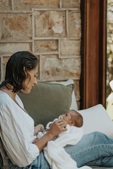 natural, lifestyle newborn photograph of mom looking down at baby