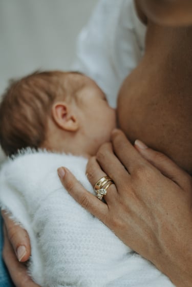 natural, lifestyle newborn photograph of baby breastfeeding