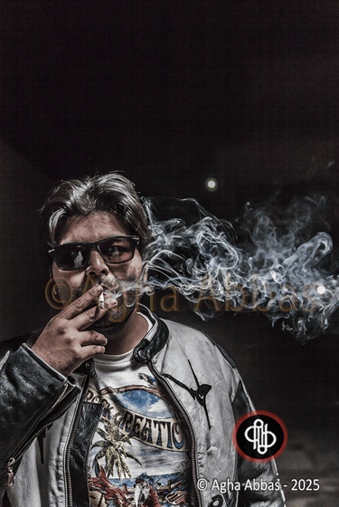 Gray-haired man in sunglasses, leather jacket, and beach t-shirt, holding cigarette with smoke, 