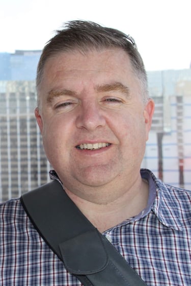 Two adults posing inside observation wheel cabin with city skyline in background, capturing a moment of leisure