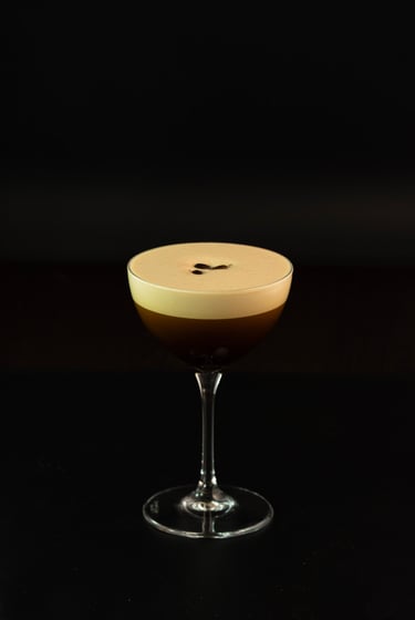Espresso-Martini-Cocktail mit cremigem Schaum und Kaffeebohnen-Garnitur in einem Coupéglas.