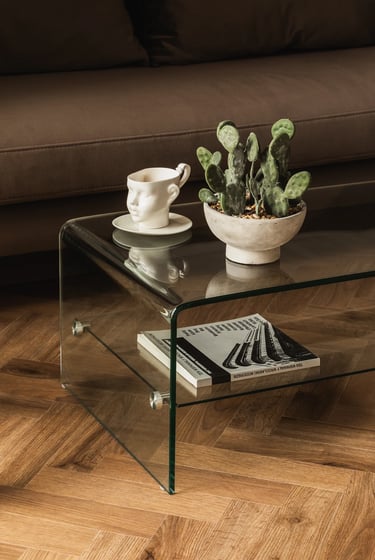 Sesja wnętrzarska: szklany stolik kawowy i dekoracje w salonie. Profesjonalne zdjęcia wnętrz.