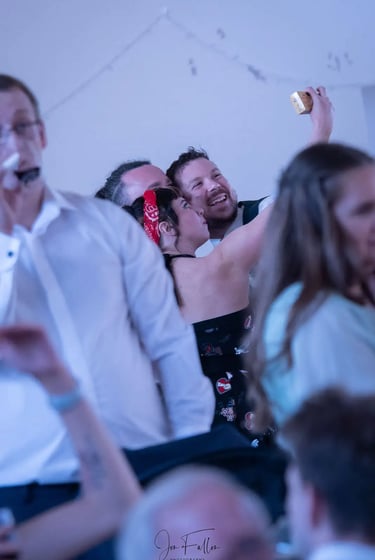 Smiling friends taking a selfie with a smartphone at a wedding reception party.