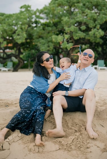 Family sitting together on the beach enjoying a relaxed afternoon at Nusa Dua Beach Bali