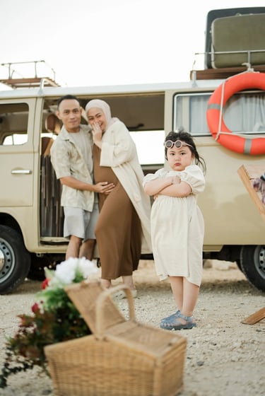 Lifestyle family portrait beside a vintage combi van at Melasti Beach Bali during sunset