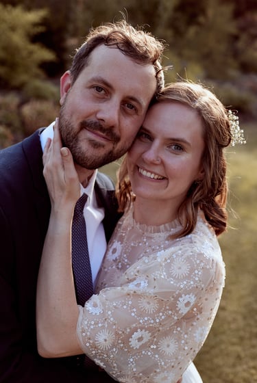 Smiling bride and groom touching heads.