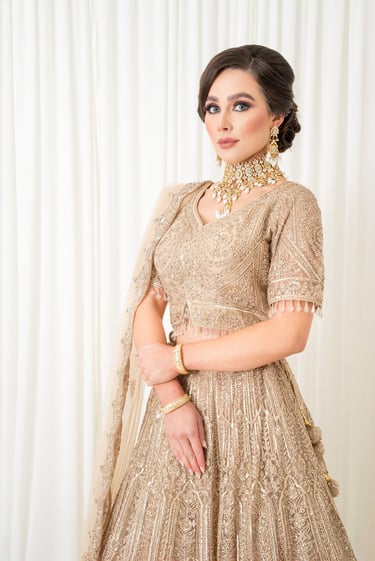 elegant asian bride dressed in traditional gold outfit with soft glamour makeup in a fashion pose 