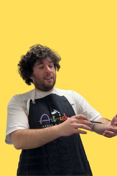 Jordan in a apron holding a paintbrush