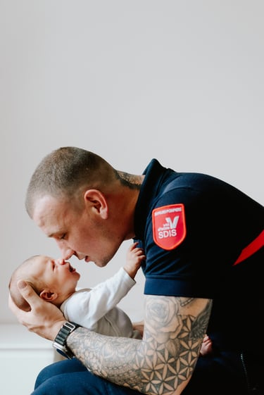 photo d'un père tenant son bébé dans les bras et collant son né au sien