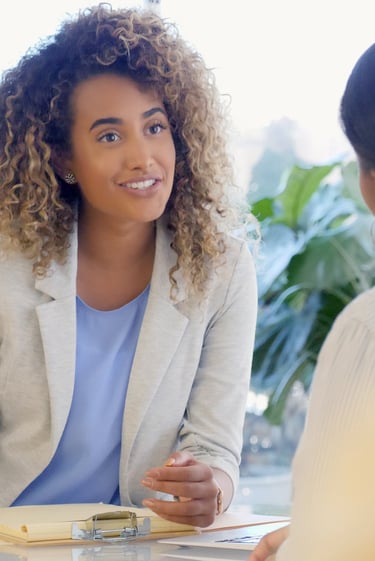  Femme portant une veste blanche  qui parle à une autre femme