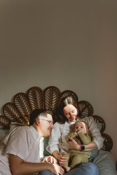 plan large de deux adultes et un bébé assis sur un lit