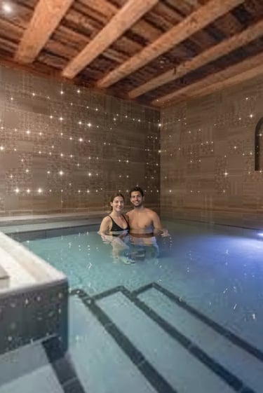 A couple relaxing in a dimly lit, atmospheric indoor thermal pool at Aqua Dome, a premier luxury wel