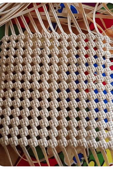 Base structure of a handmade woven bag using natural colored recycled plastic strips at Craftvitas Indonesia.