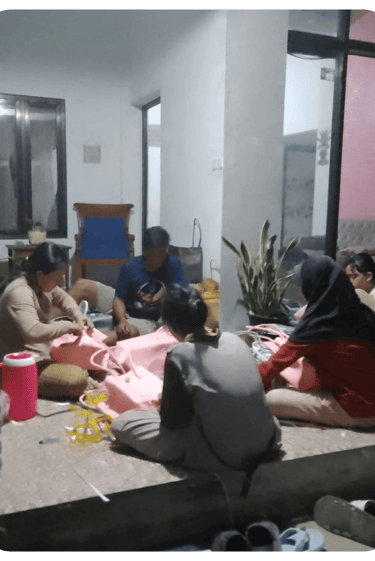 Community artisans handweaving plastic woven bags together in a home production setting at Craftvitas Indonesia.