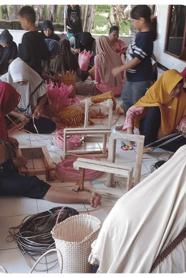 Artisans finishing colorful jali jali plastic woven bags by hand at Craftvitas Indonesia workshop.