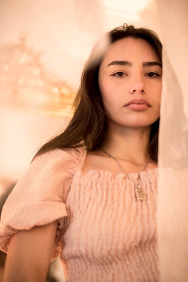 une jeune femme brune avec les cheveux longs et un collier
