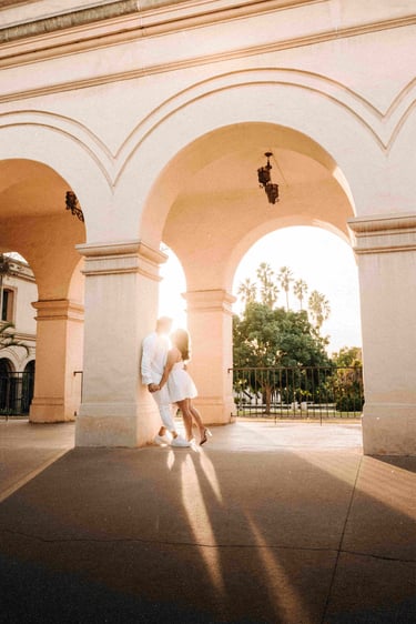 A photo of a young couple kissing under ornate pillars