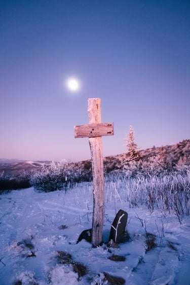 Wooden Appalachian Trail signpost on a snowy Grassy Ridge Bald at dawn with a bright moon.