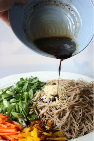 pouring sauce on Potluck Soba Salad