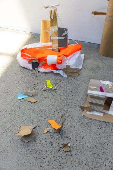 A bright orange and white cardboard structure on the floor.
