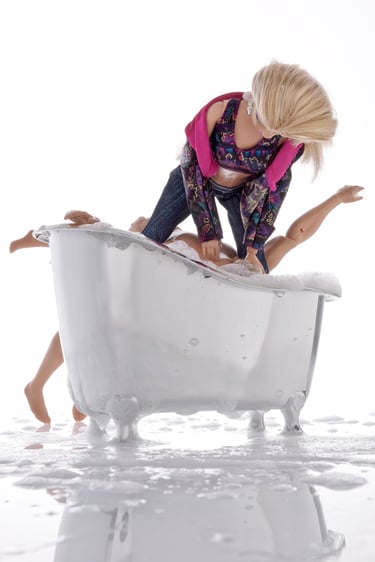 a blonde haired woman in a bathtub with a doll