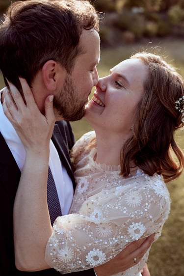 Bride and groom touching noses.