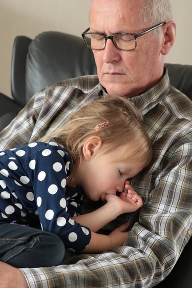 a man and a little girl are sitting on a couch