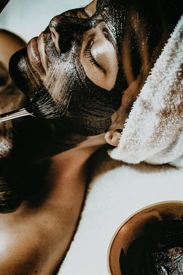 mulher deitada de olhos fechados fazendo argiloterapia.