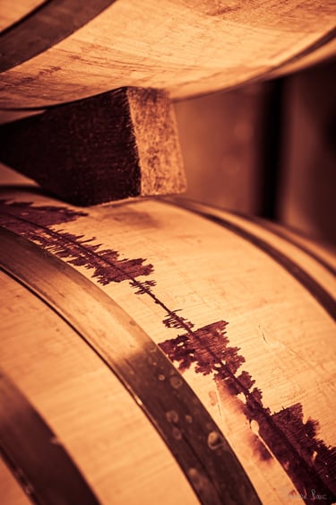 Détail d’un fût marqué par une coulée de vin rouge sombre, cicatrice symbolique.