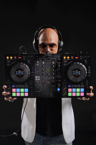 a man in a white suit, sunglasses and headphones holding a DJ controller