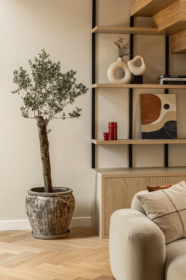 Kadr na zabudowę pod schodami: drewniane półki i zieleń we wnętrzu.