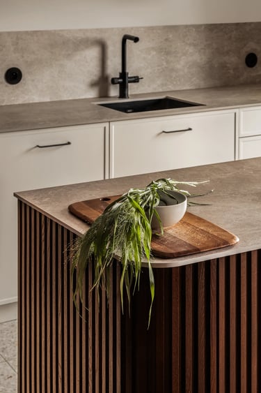 Zdjęcie detalu: faktura kamienia i ryflowana wyspa kuchenna.