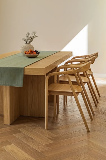 Stylizacja do sesji wnętrz: detale na dębowym stole i lniany bieżnik.