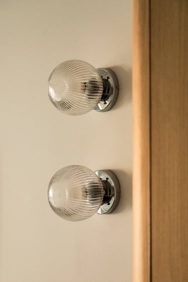 Fotograf wnętrz: szklane kinkiety ryflowane – detal oświetlenia w sesji apartamentu.