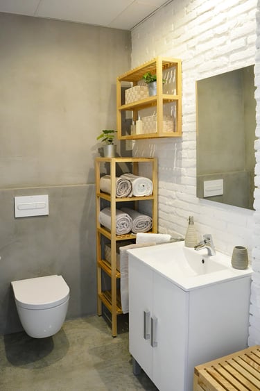 Reforma de baño con microcemento y ladrillo caravista blanco, realizado por los mejores interioristas de Valencia