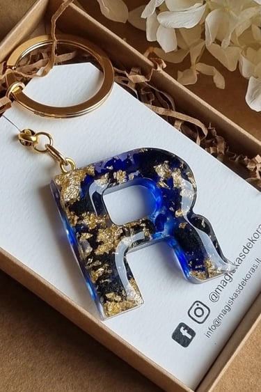 a keychain with a blue and gold foiled initial letter r