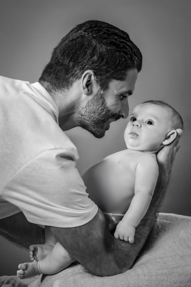 "Un retrato de familia en blanco y negro, padre con bebé en brazos"