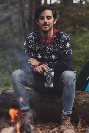 a man sitting on a log log in the woods