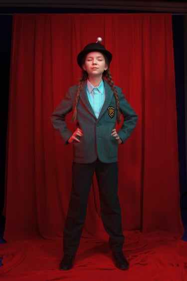 a young girl in a suit and hat