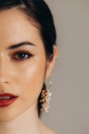 a woman with a red lipstick and earrings