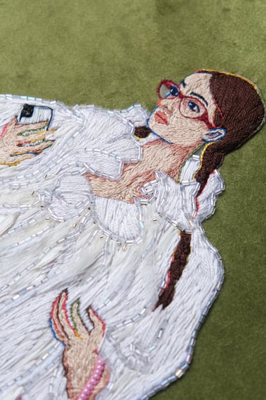 a woman in a white fur coat and boots embroidery and beaded pink bag