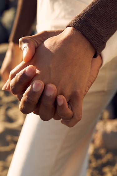 Close-up of two people holding hands representing emotional support, trust, and compassionate care