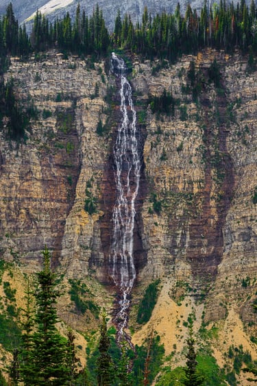 Crypt Falls cascading down a tall cliff in Waterton Lakes National Park, Alberta.