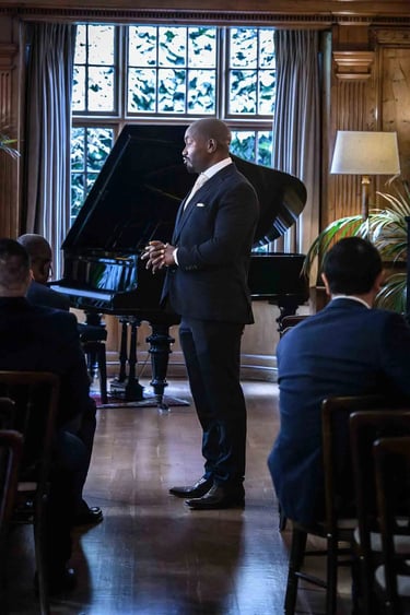 groom standing in front of a grand piano waiting for his bride